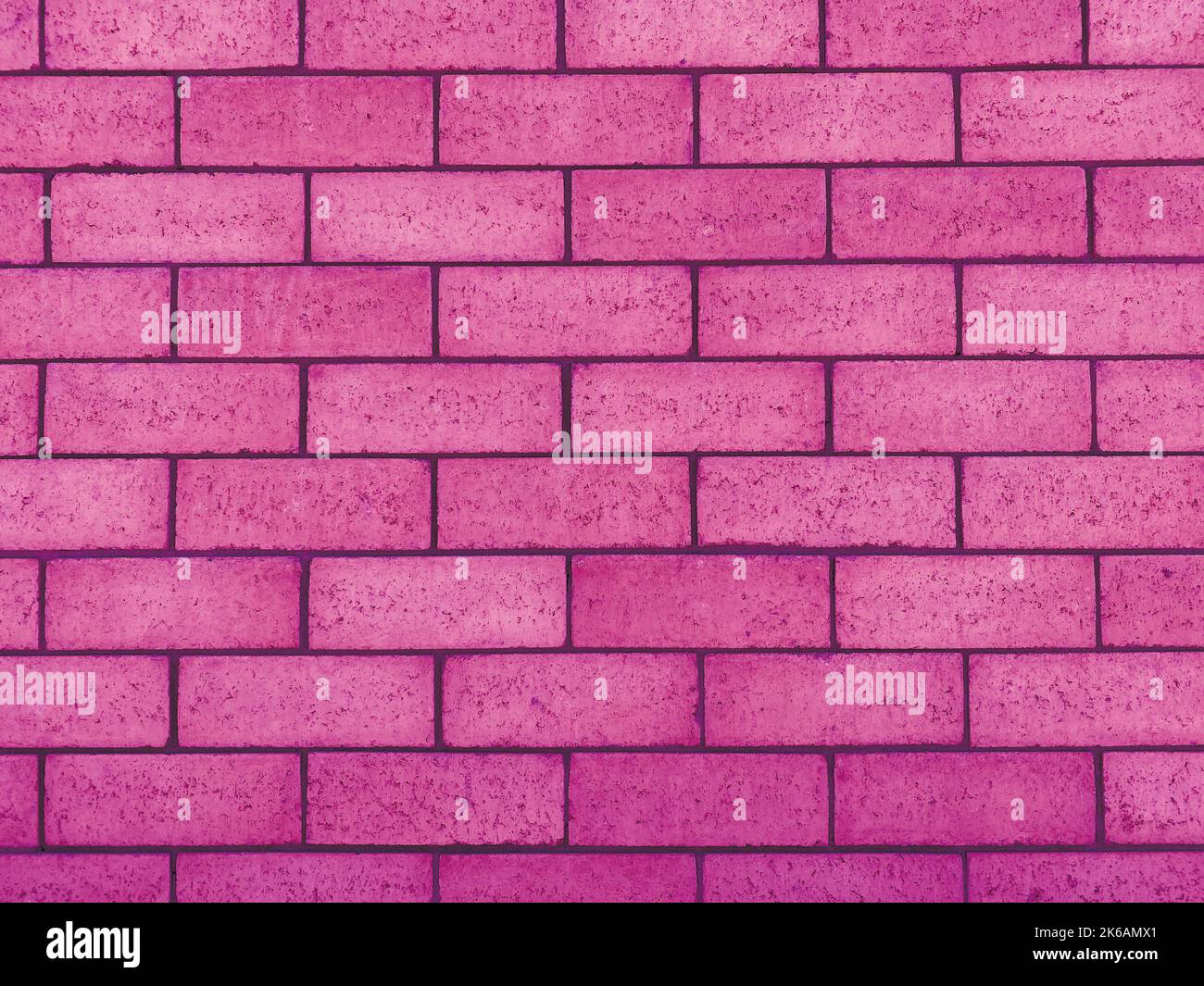 a pink cinder block concrete wall painted shadow building strong shadows closeup cement garden facade Stock Photo