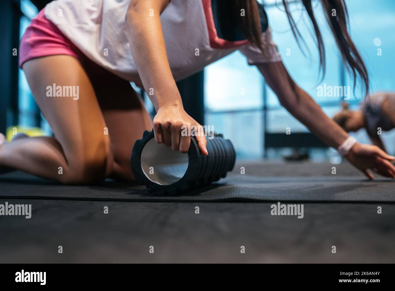 Young woman using a foam roller while doing stretching exercises Stock ...