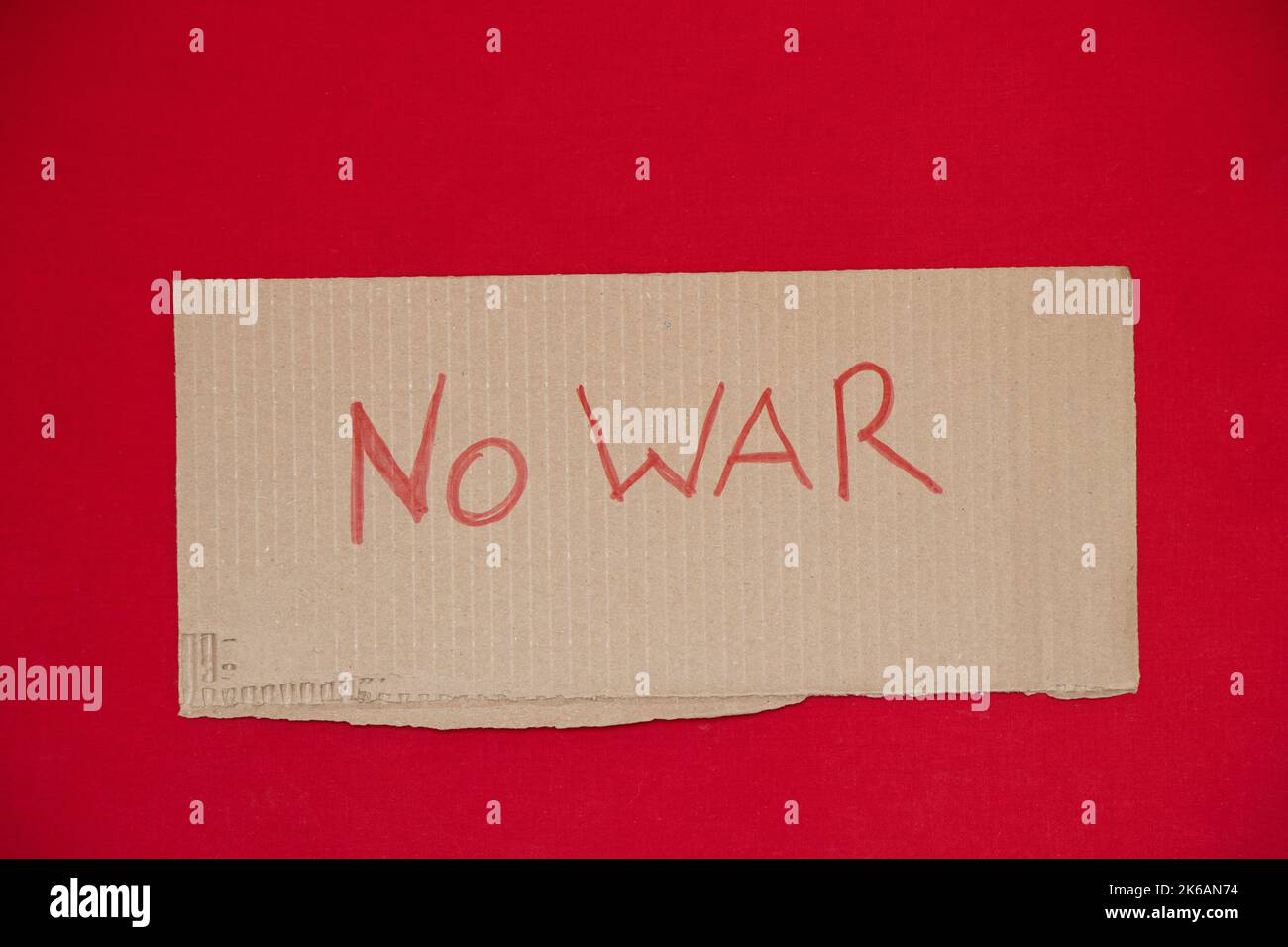 Paper signs with slogans no war on a red background, the war in Ukraine