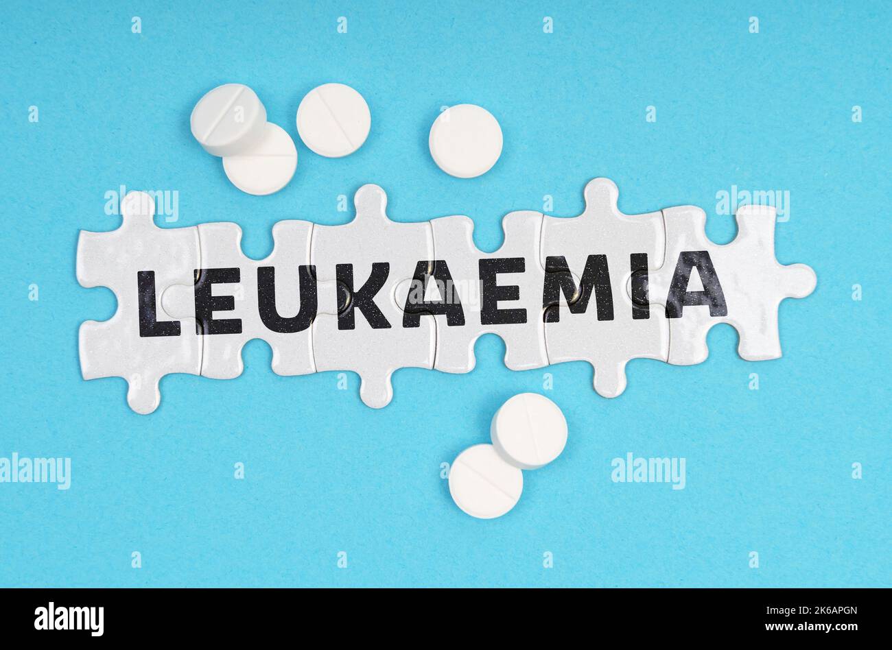 Medicine concept. On a blue background pills and puzzles with the inscription - LEUKAEMIA Stock Photo