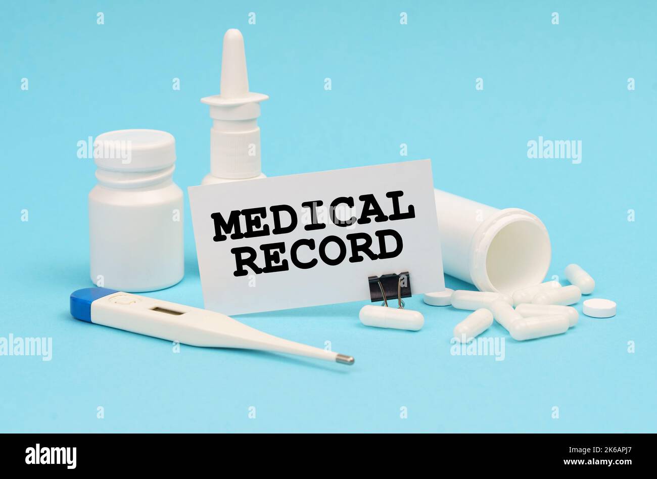 Medicine concept. On a blue background, a thermometer, pills and a business card with the inscription - Medical Record Stock Photo