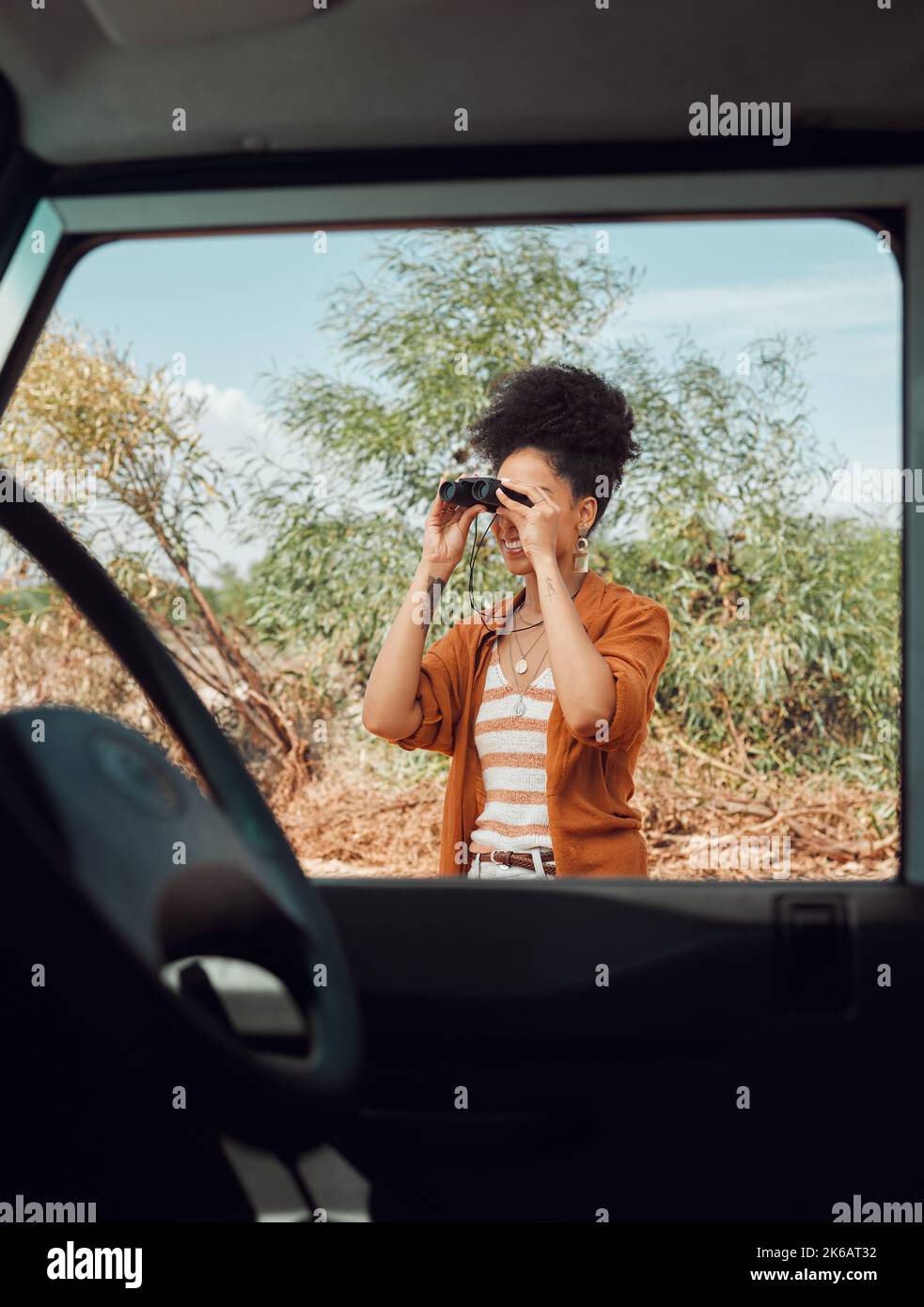 Road trip, travel and binoculars with a sightseeing woman outdoor in nature for a summer vacation or weekend getaway. Freedom, holiday and vehicle Stock Photo
