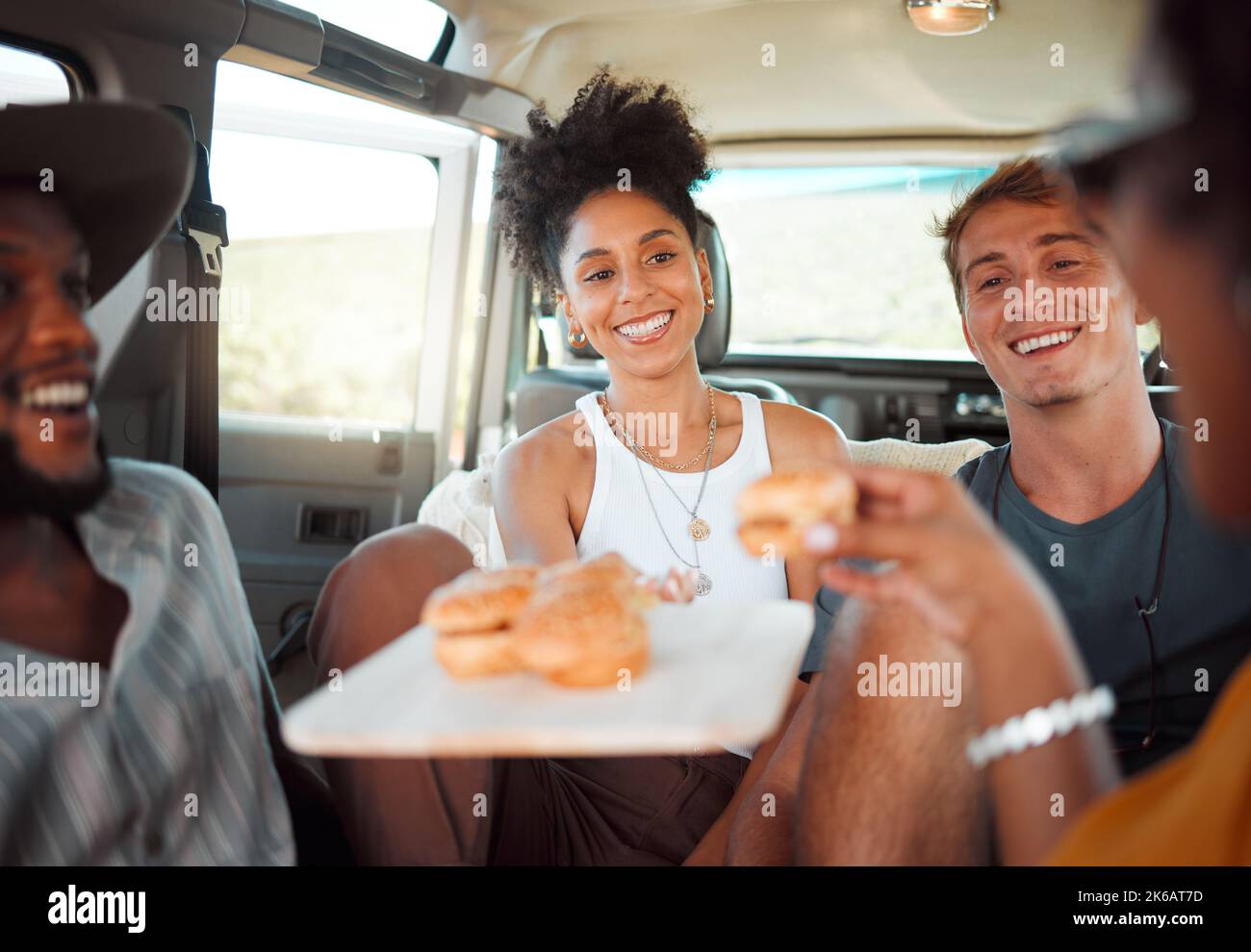 Car, road trip and diversity friends with food, burger or snacks for SUV transportation journey in Australia. Van travel adventure, happy friendship Stock Photo