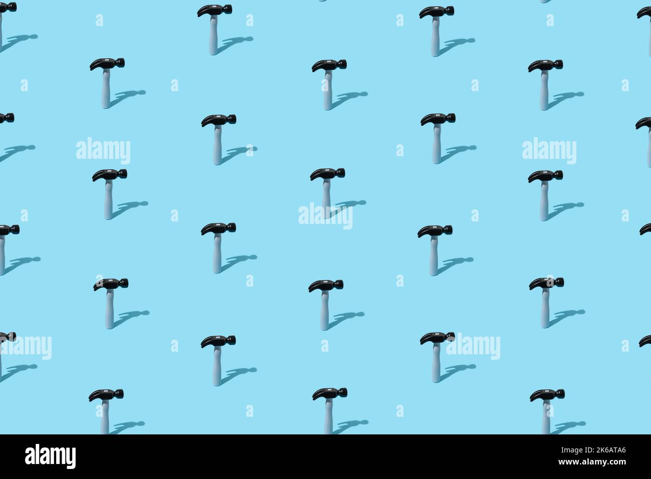 A lot of hammers as isometric grid pattern on a blue pastel background. Minimal art concept. Stock Photo