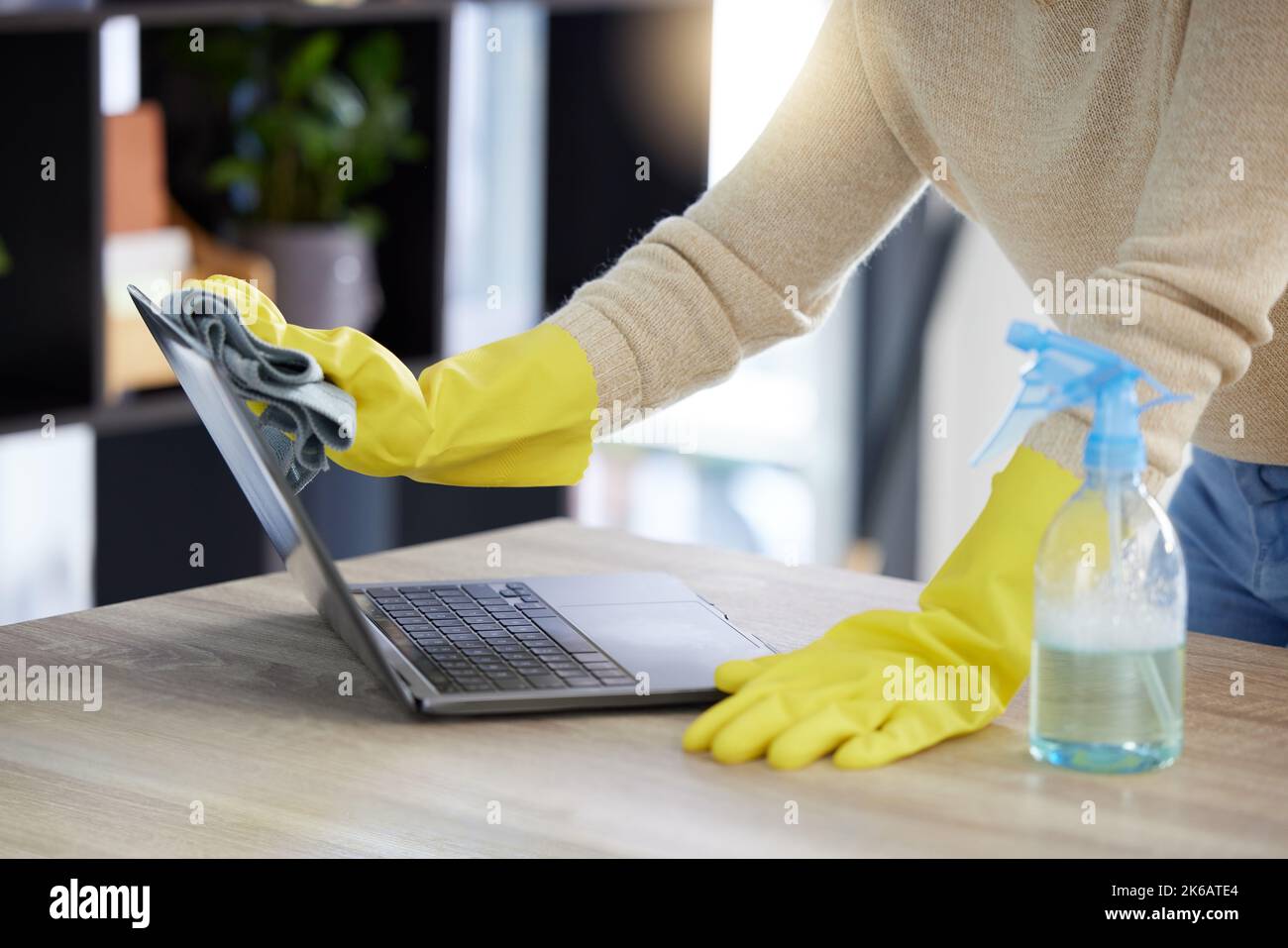 Laptop, cleaning and hands with an office cleaner wiping a computer on