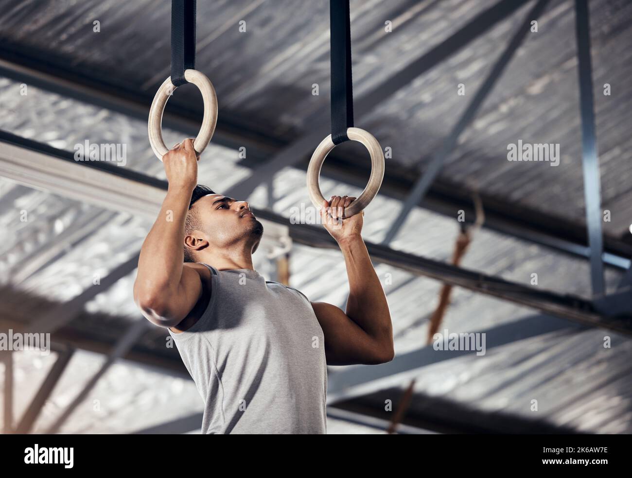 Fitness, exercise man in gymnastics gym during pull up, training or