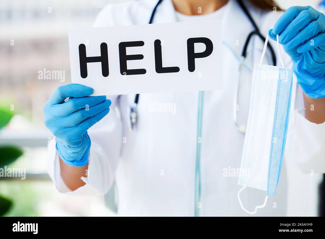 The doctor is holding a card with the Help symbol in the office of the ...