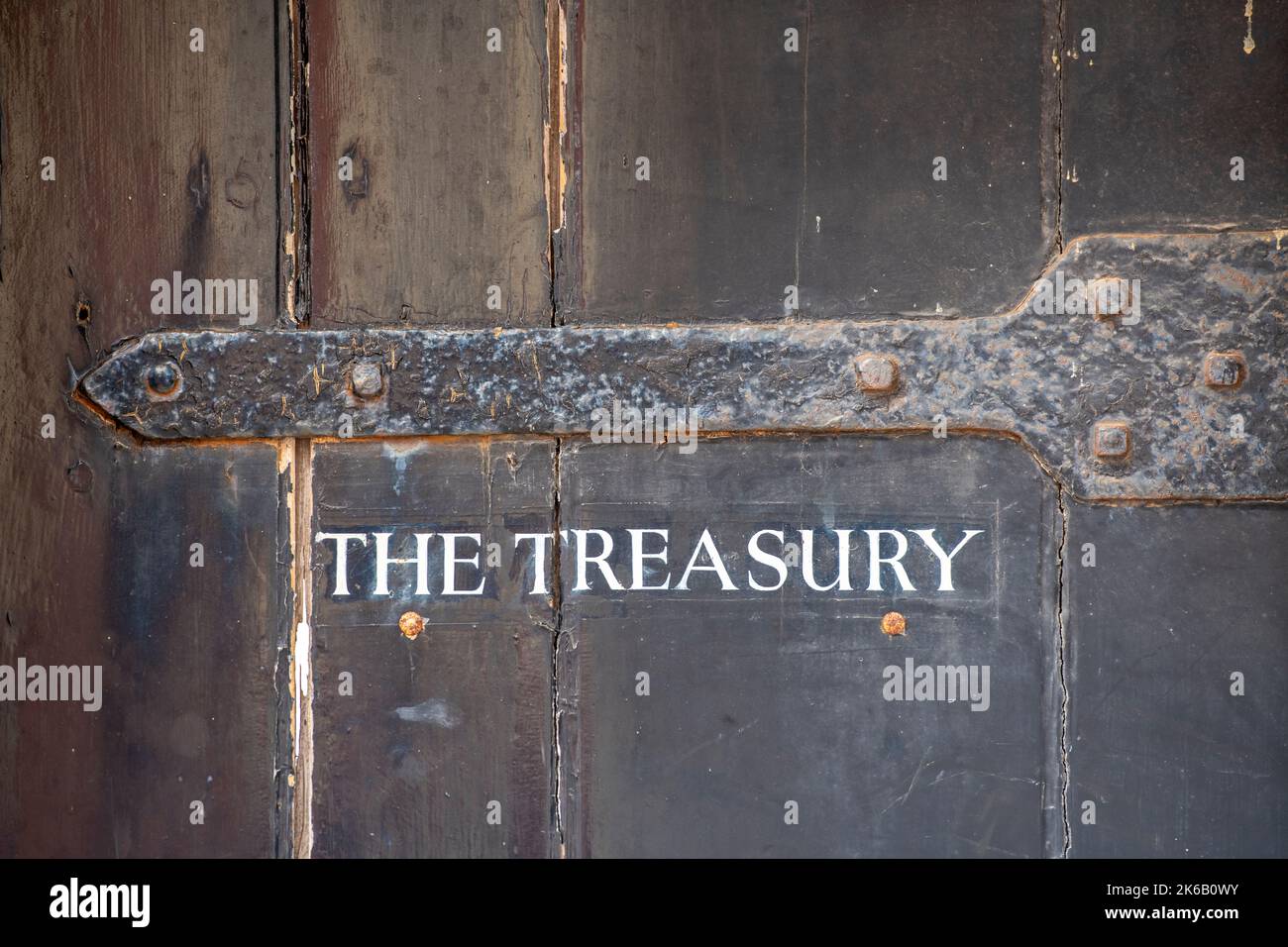 the treasury, large antique sign, large antique door with the treasury sign on it, large strap hinge on antique door. Stock Photo