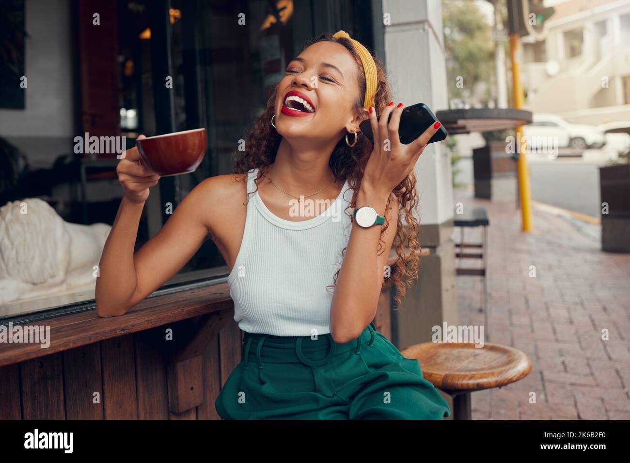 Black woman in cafe, listening to audio message on 5g smartphone and
