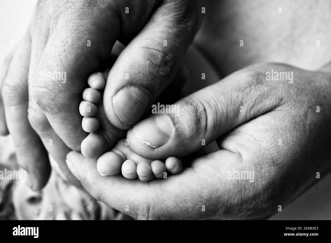 Closeup baby feet in mother hands. Prevention of flat feet, development