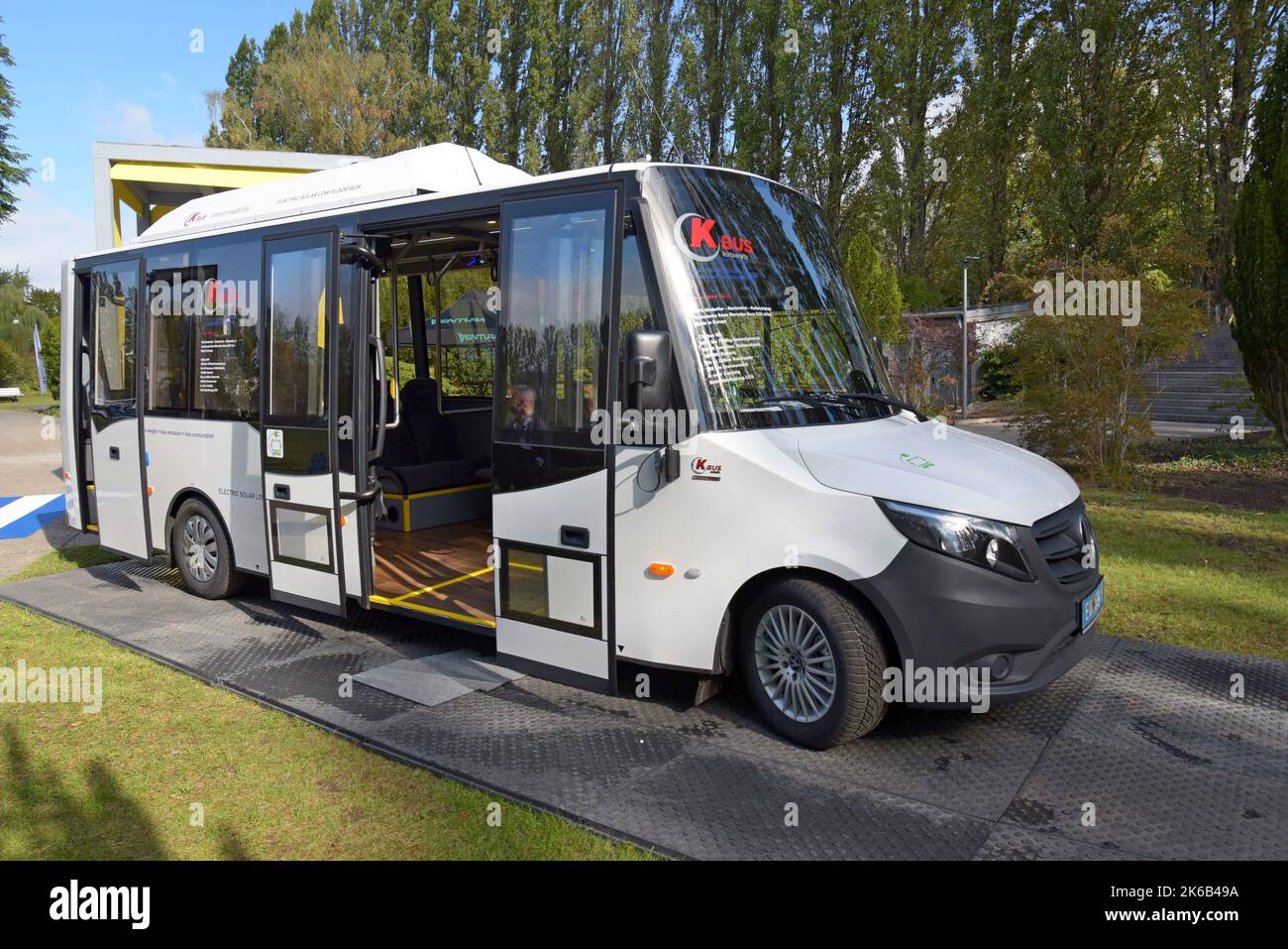 People studying the K Bus low floor emission free electric bus with solar panels at Innotrans international transport expo, Berlin Sept 2022 Stock Photo