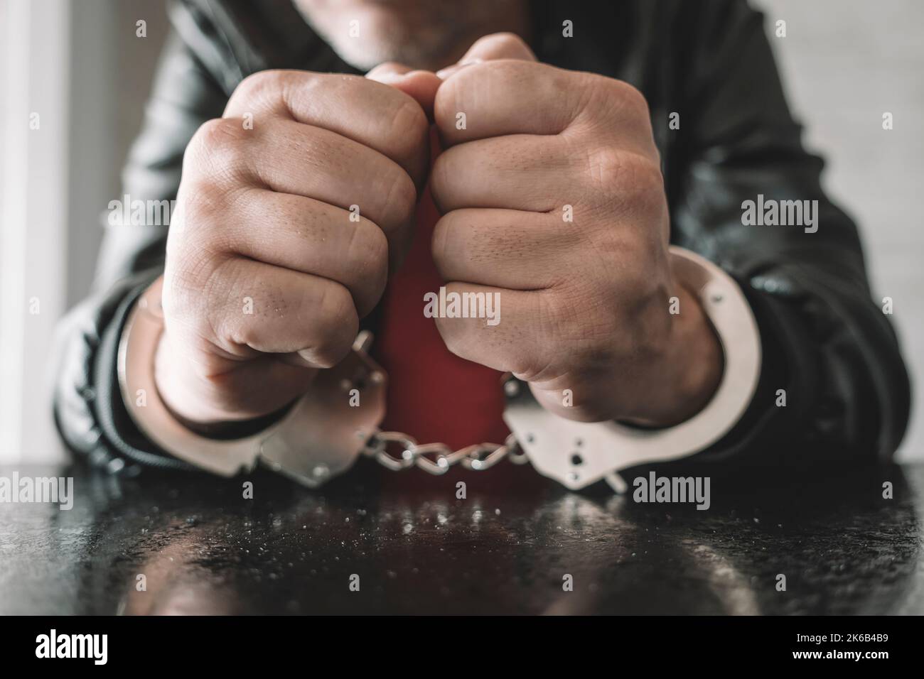 handcuffed hand is strapped inside interrogation room. the concept of arrest and incarceration. A prisoner in prison. interrogation in prison. crimina Stock Photo