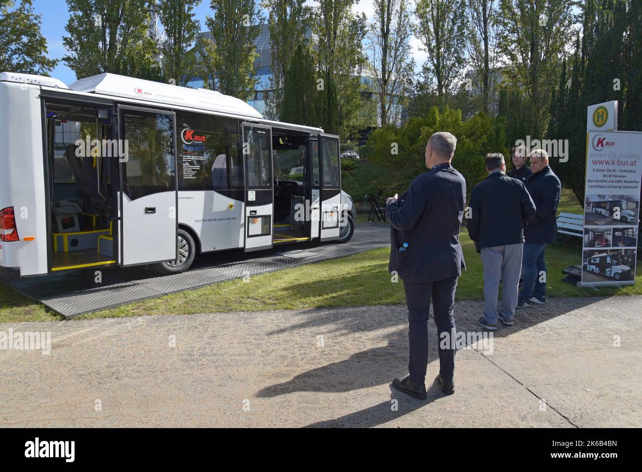 People studying the K Bus low floor emission free electric bus with solar panels at Innotrans international transport expo, Berlin Sept 2022 Stock Photo