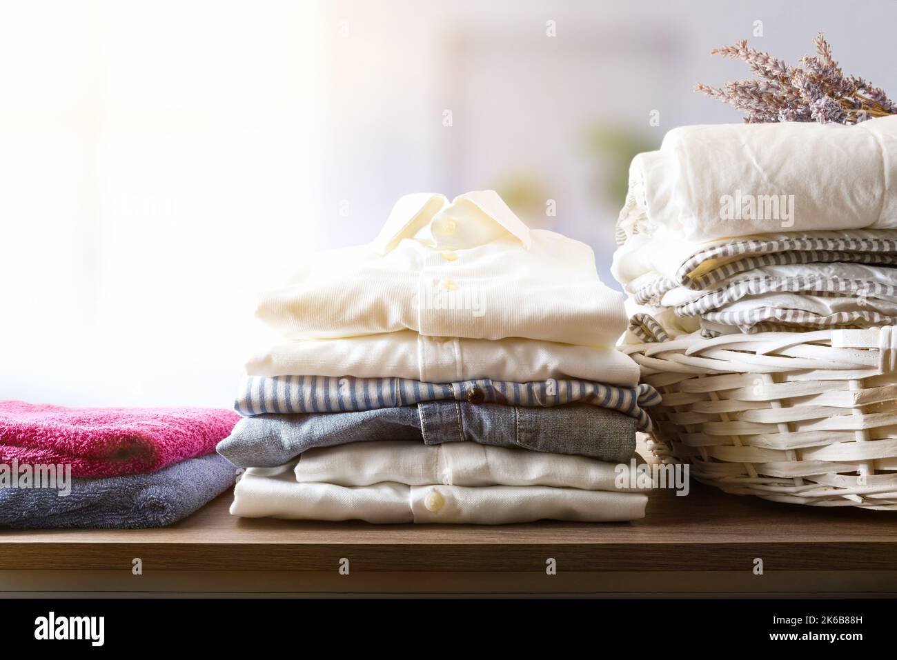 Clean clothes folded on a wooden shelf in a rooms on a wooden shelf in bedroom. Front view. Horizontal composition. Stock Photo