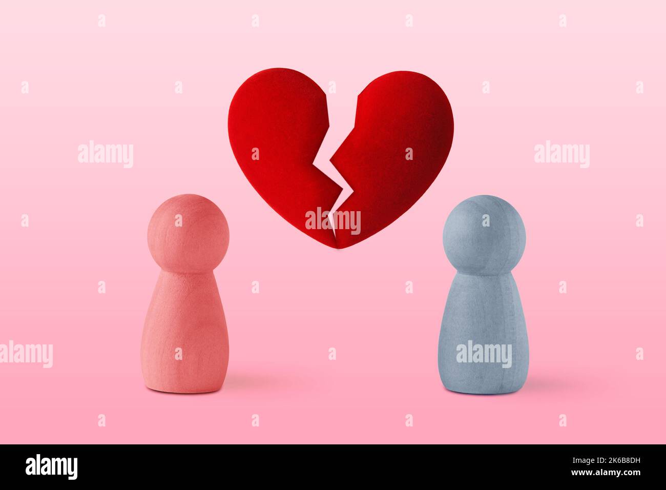 Pink and blue pawn with broken heart - Concept of love ending and divorce Stock Photo
