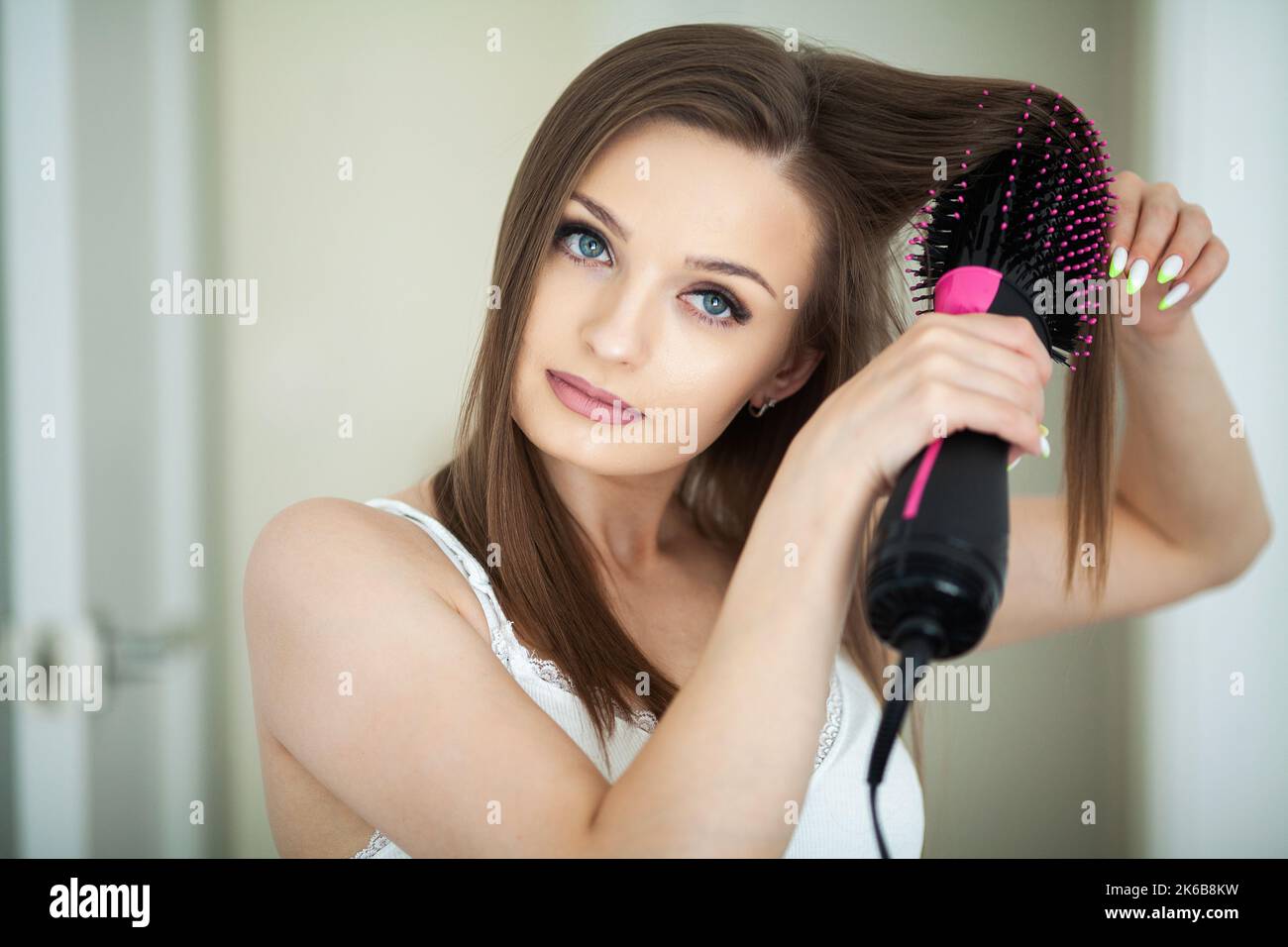 Woman drying long hair with hair dryer round brush Stock Photo Alamy