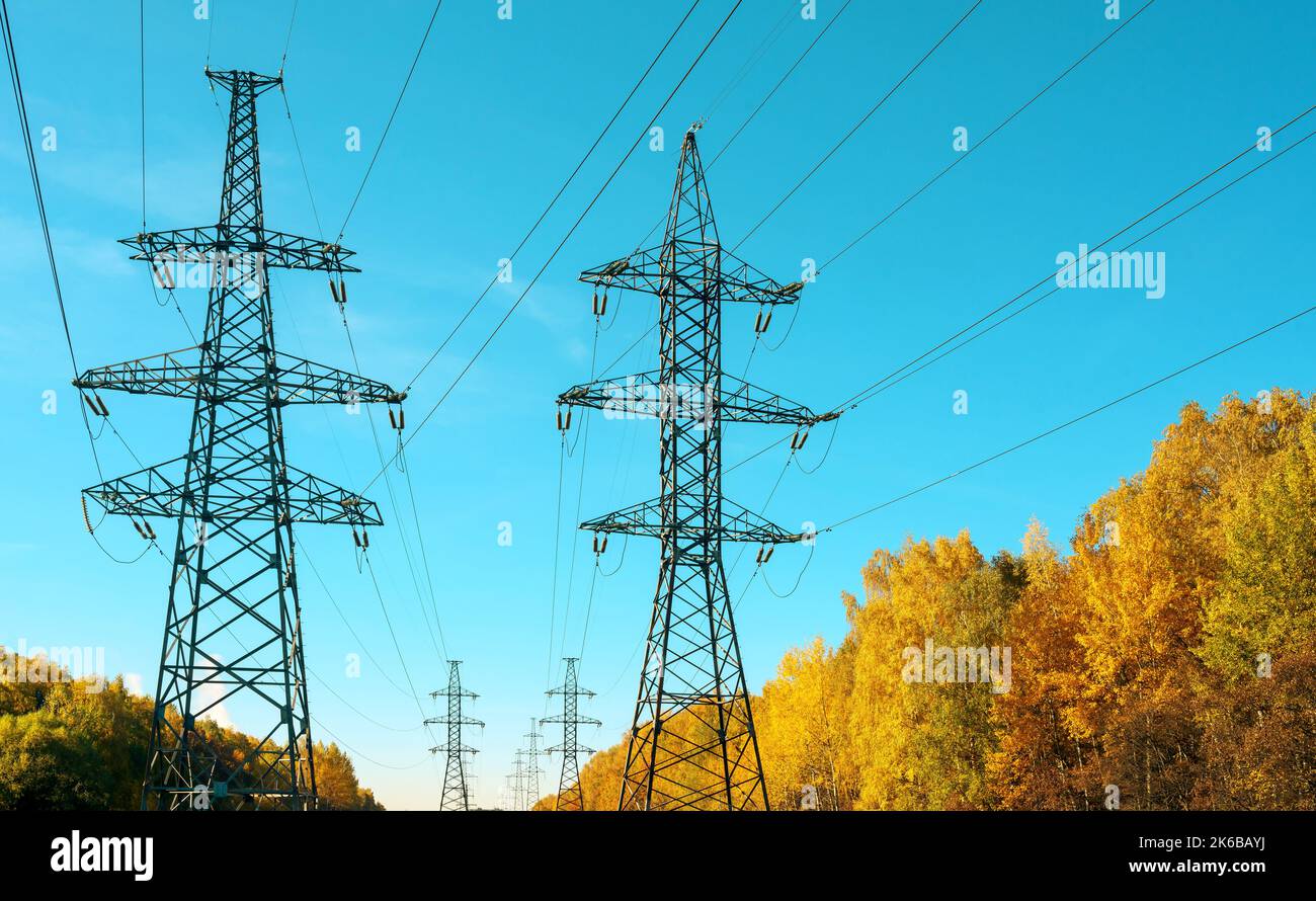 Power lines and a towers against a background of blue sky in autumn ...