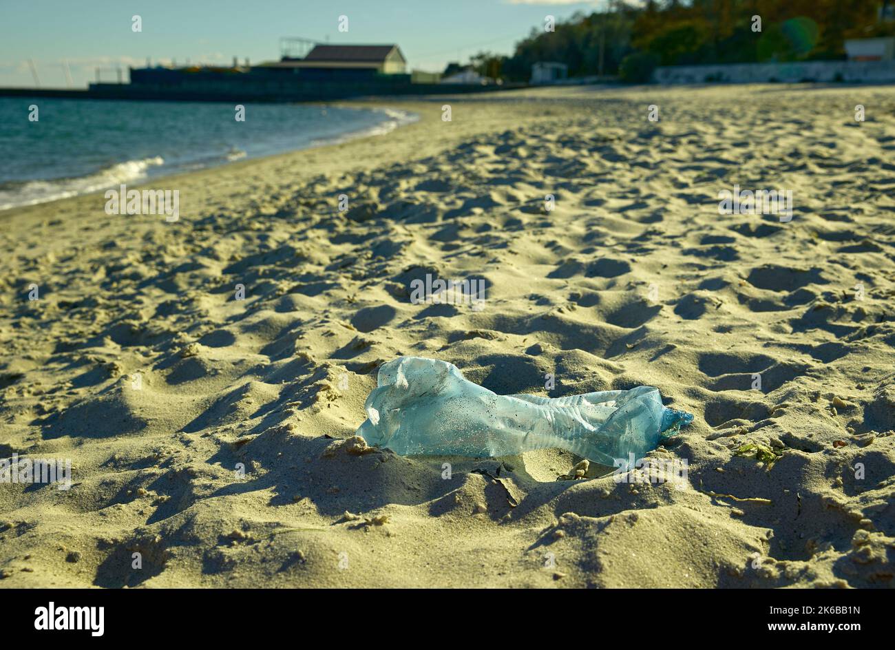 A plastic bottle is lying on a deserted seashore Stock Photo
