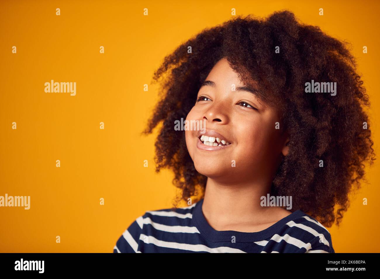 Studio Portrait Of Smiling Young Boy Shot Against Yellow Background Stock Photo
