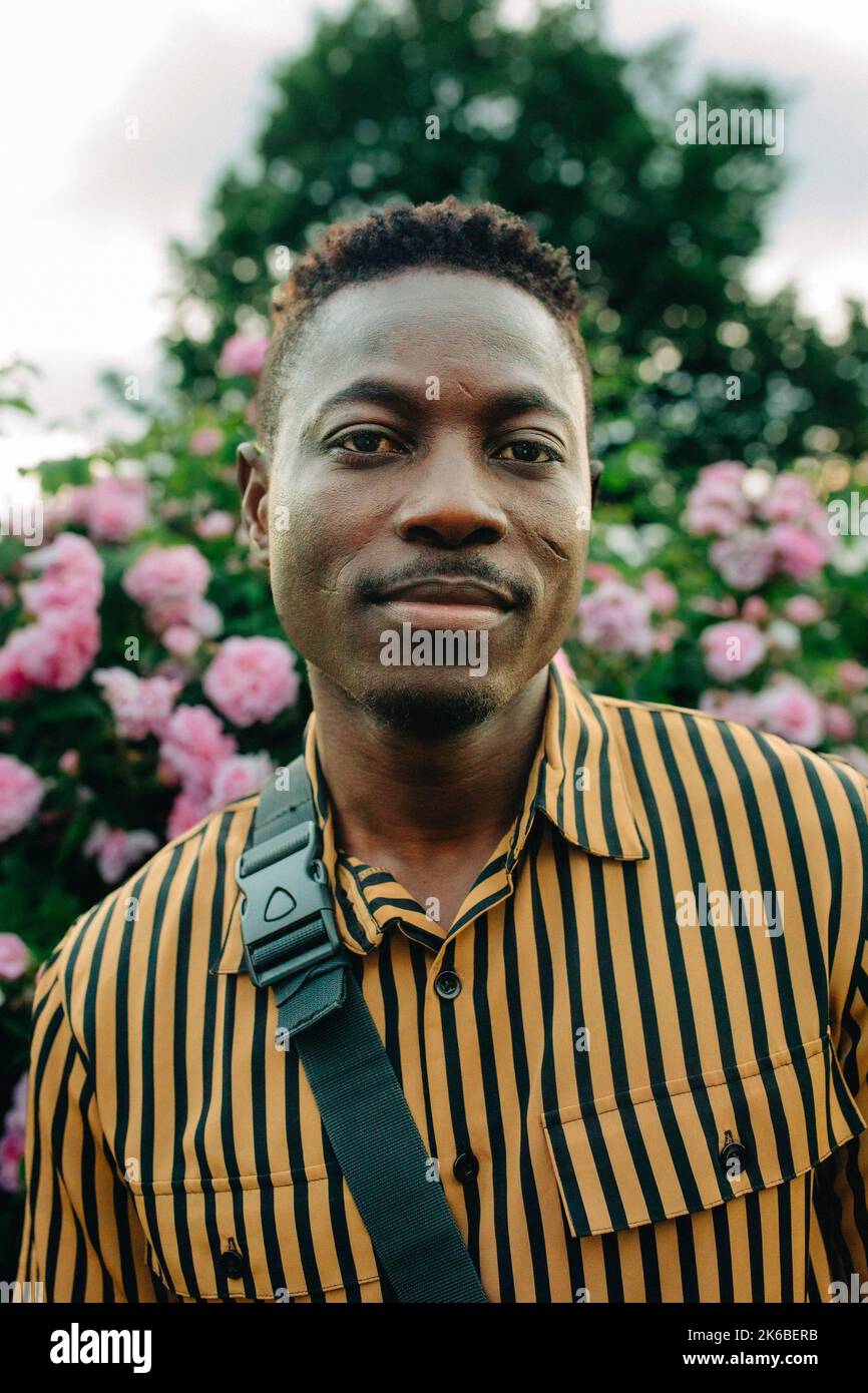 Portrait of man wearing striped shirt in garden Stock Photo