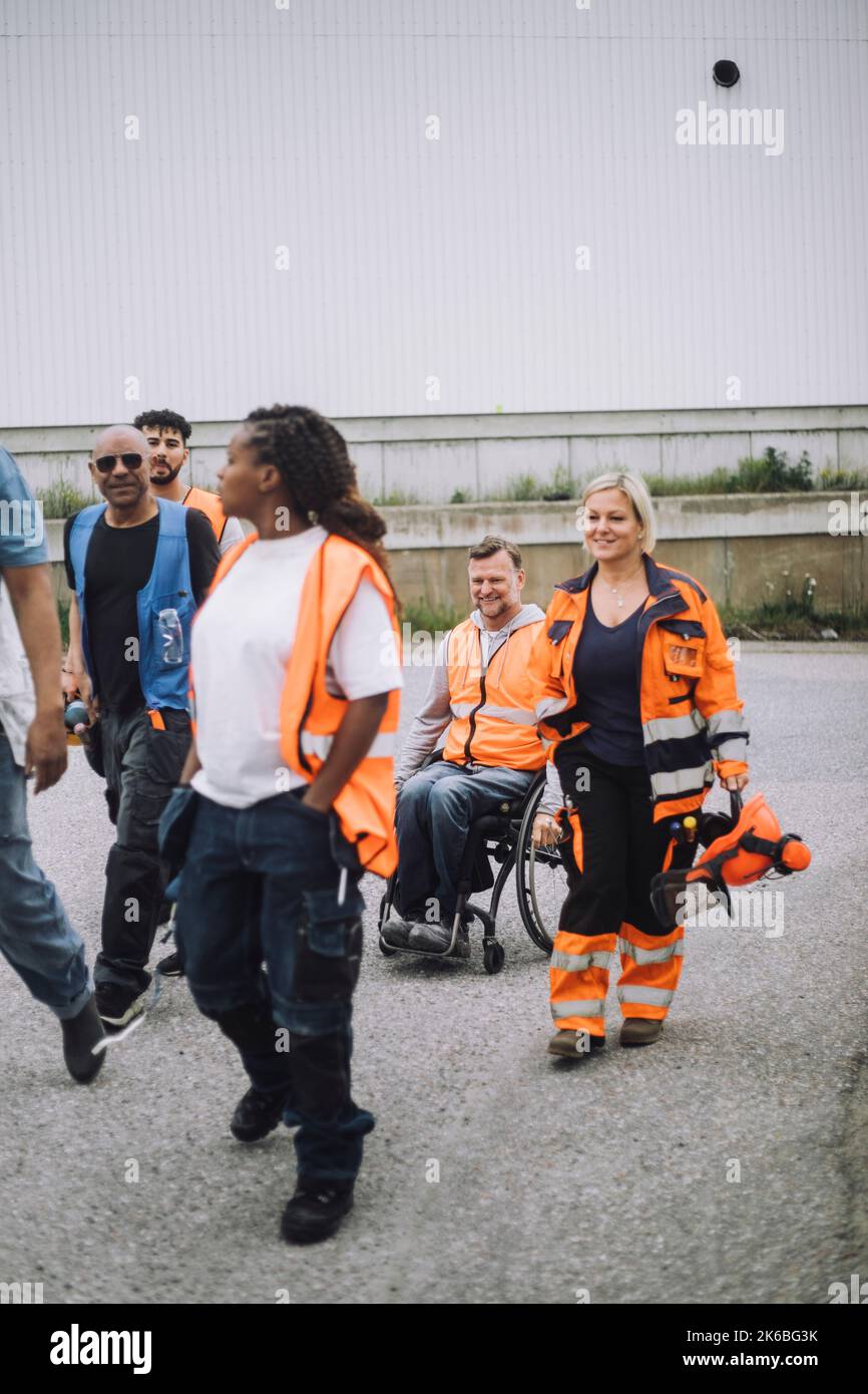 Male And Female Construction Worker Walking With Disabled Colleague On male-and-female-construction-worker-walking-with-disabled-colleague-on