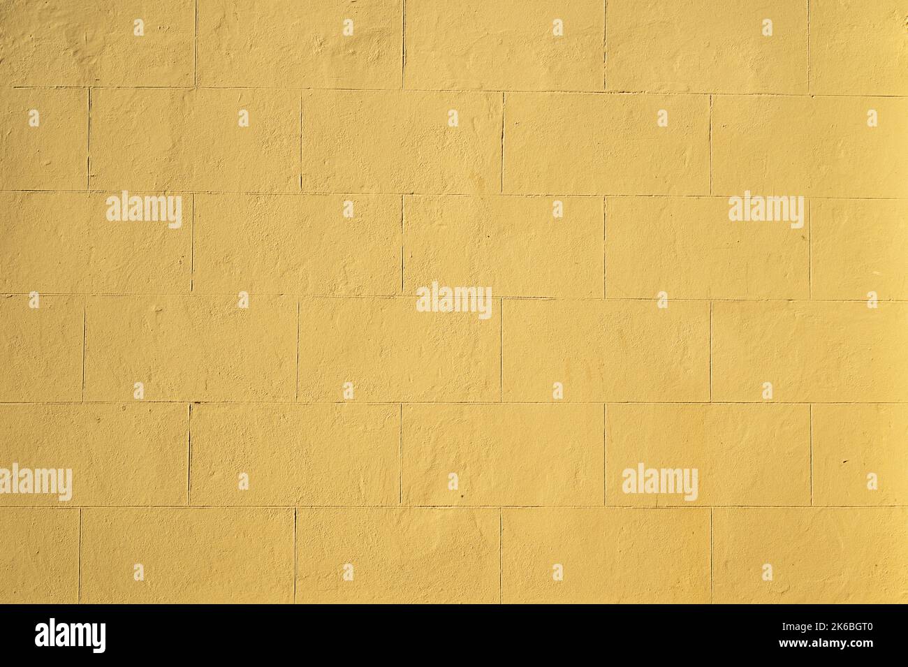 Yellow Painted Plaster Wall from 1850s with Lines Simulating Large Stone Bricks Stock Photo