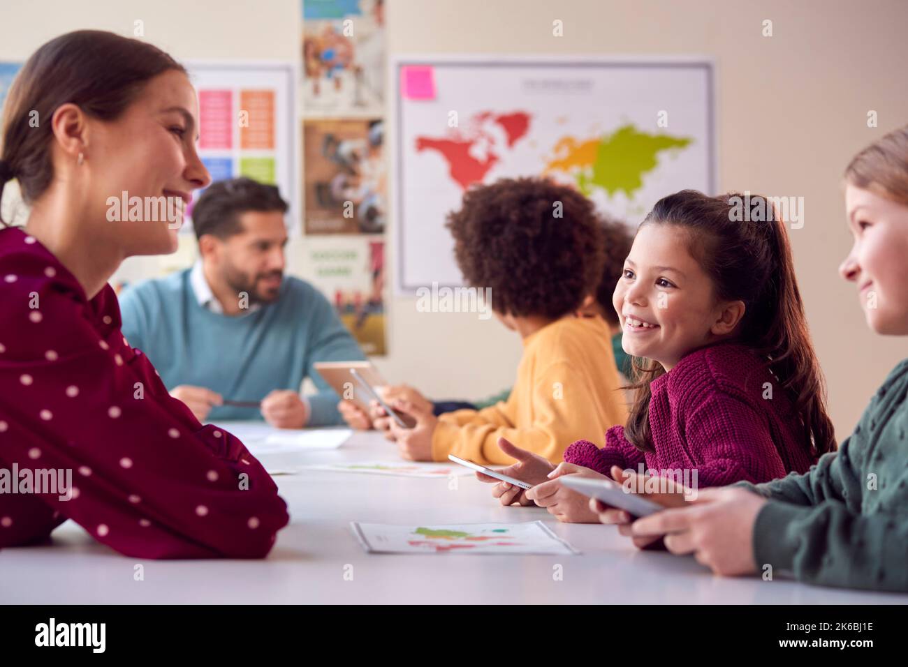Group Of Multi-Cultural Students With Teachers In Classroom Using Digital Tablet In Lesson Stock Photo