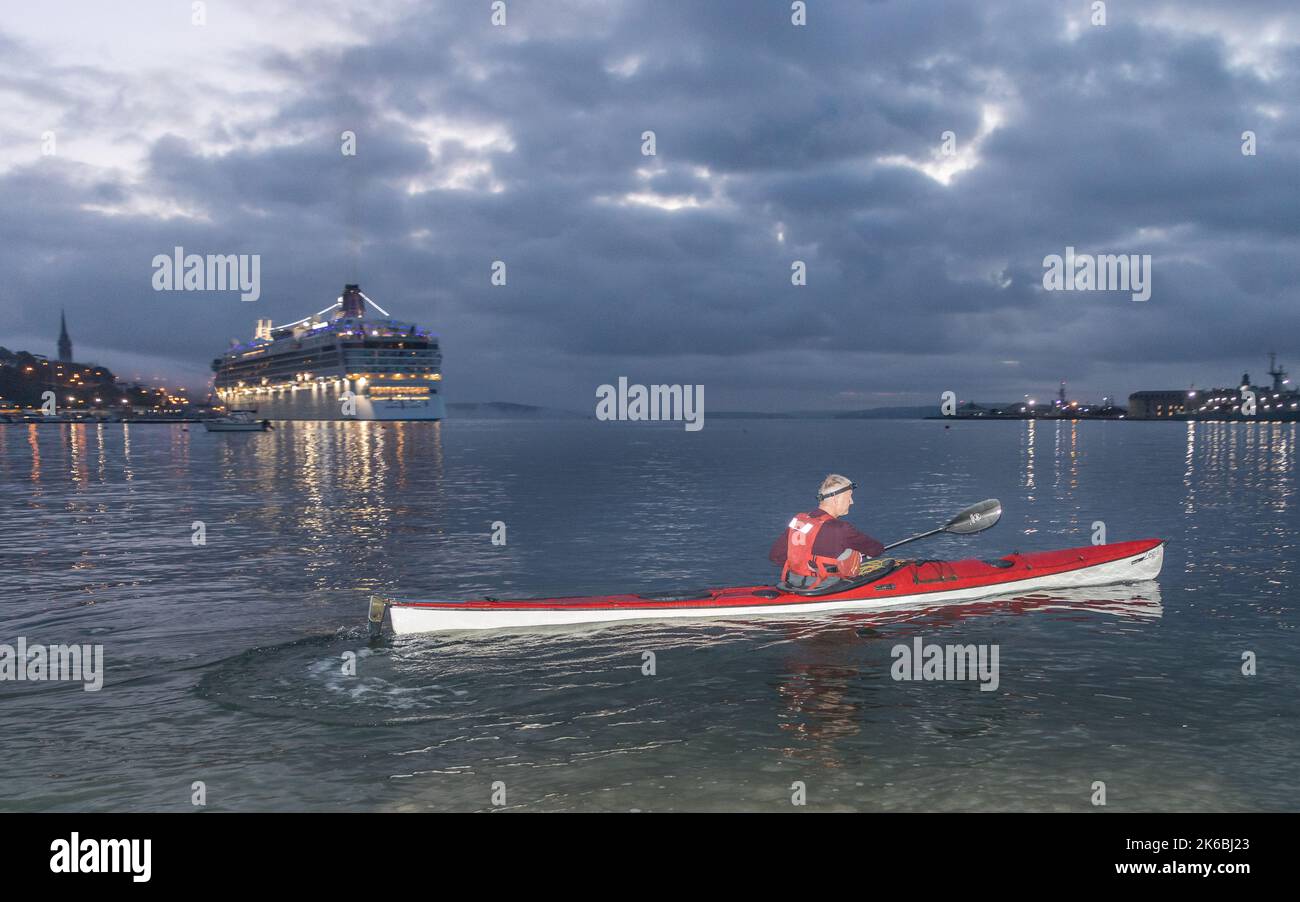 Cobh, Cork, Ireland. 13th October, 2022. Kayaker Paddy O' Donovan heads out for his daily morning paddle around Spike Island as the cruise ship Norwegian Dawn arrives before dawn in Cobh, Co. Cork, Ireland. - Credit; David Creedon / Alamy Live News Stock Photo