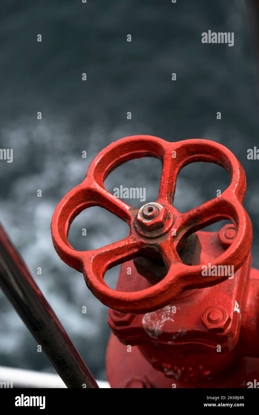 Isolated red valve used on the ship. selective focus valve. Stock Photo