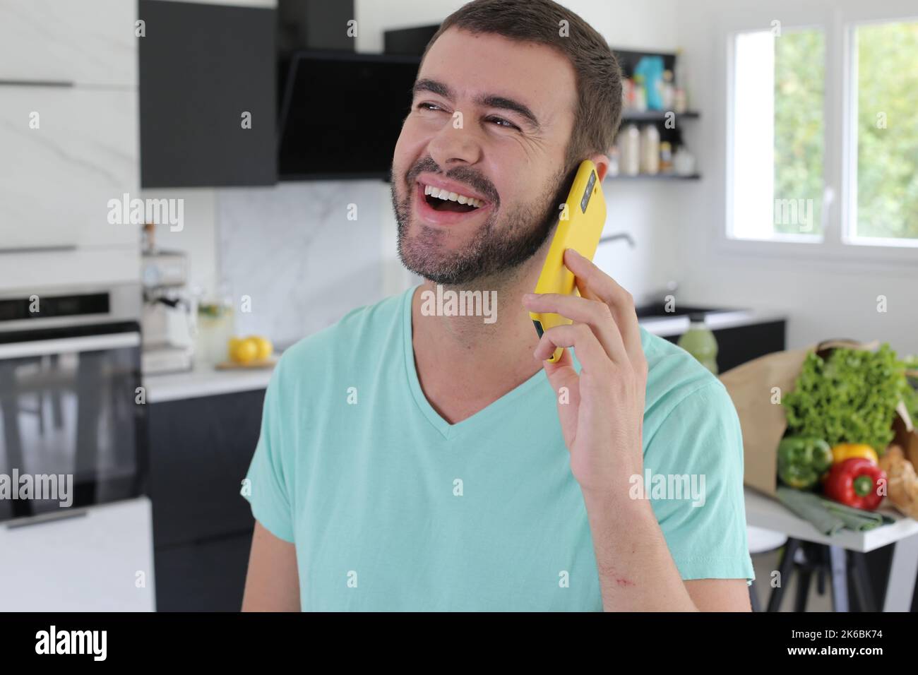 Handsome man calling from his kitchen Stock Photo