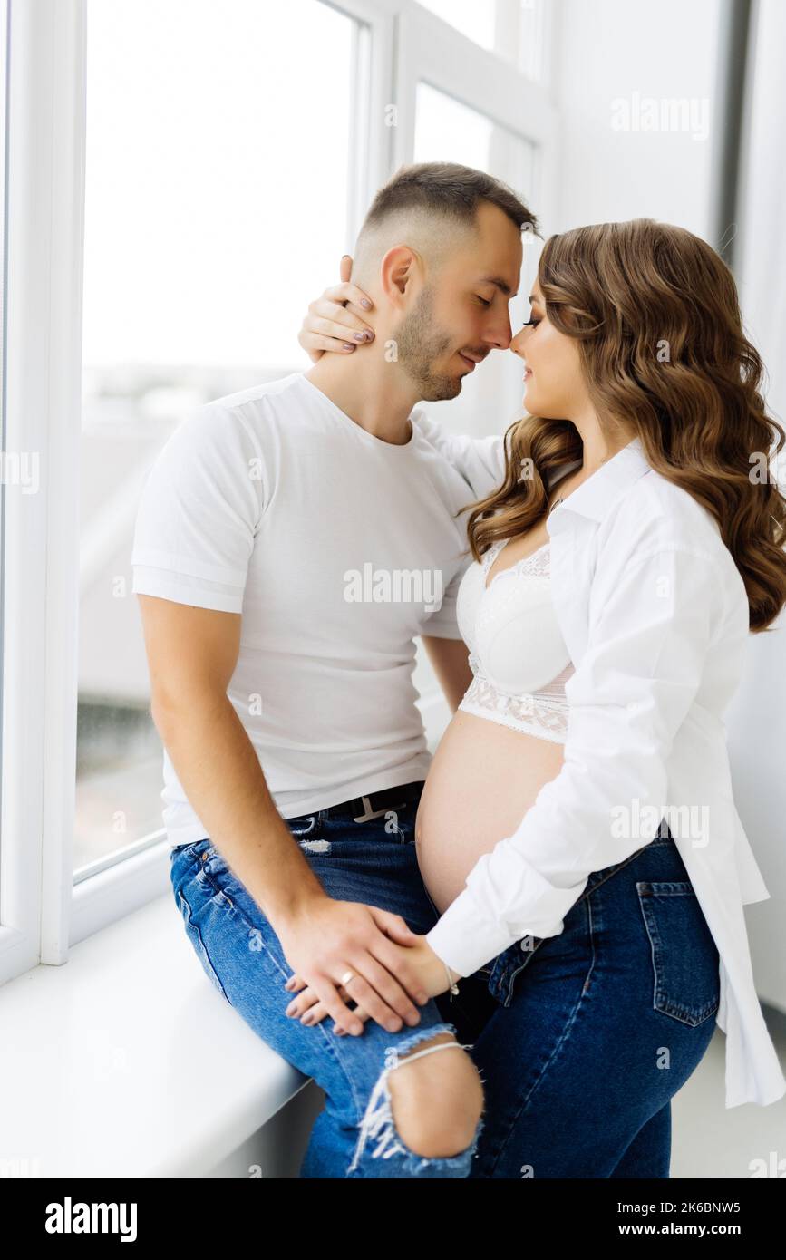 Pregnancy couple hugging window hi-res stock photography and images photo