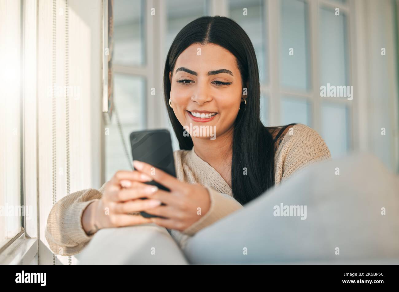 Lets hang. an attractive young woman texting while chilling at home ...