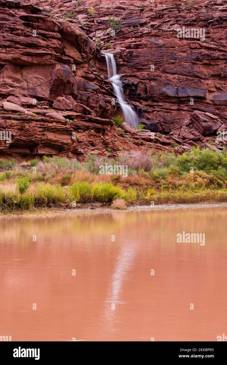 An ephermal or temporary waterfall on a Wingate sandstone cliff near Moab, Utah.  A slow shutter speed gives a silky look.  These waterfalls only occu Stock Photo