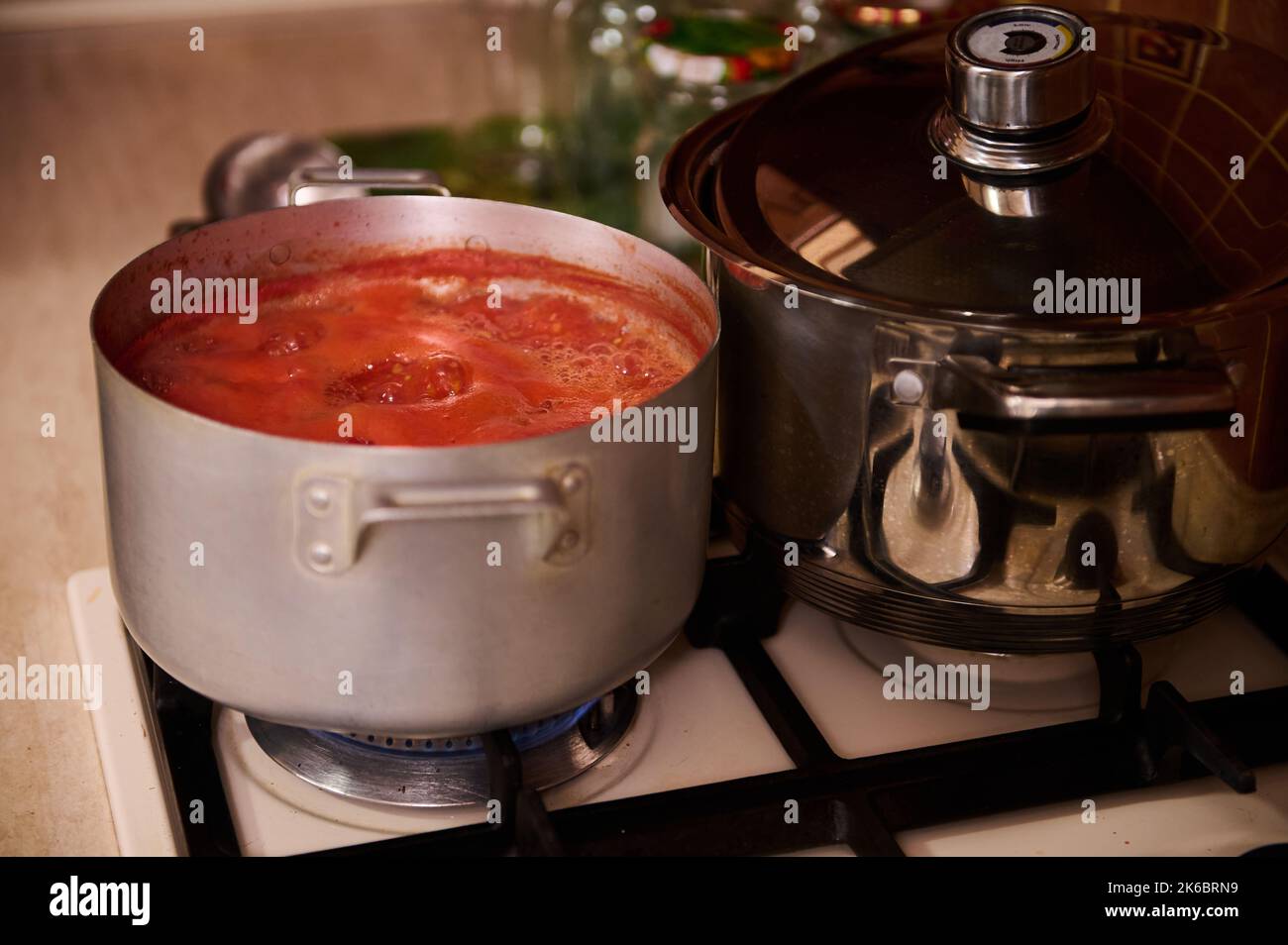 Top view of stirring boiling tomato juice, preparing homemade passata