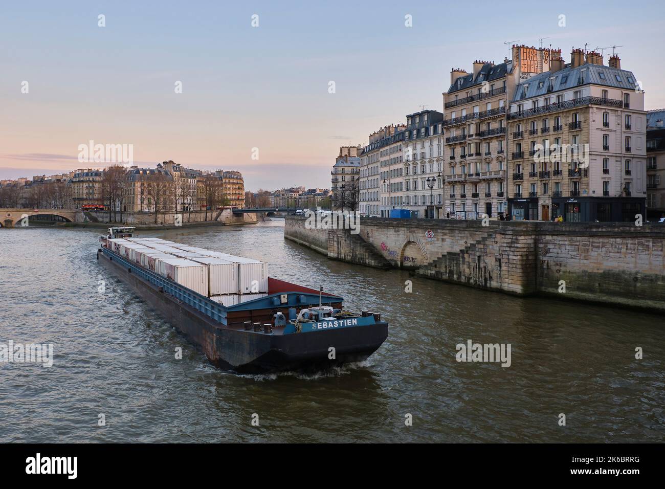 Paris (France): freight barge on the River Seine and Haussmann style buildings of the natural river island “Ile de la Cite”, “Quai aux fleurs” quay, 4 Stock Photo