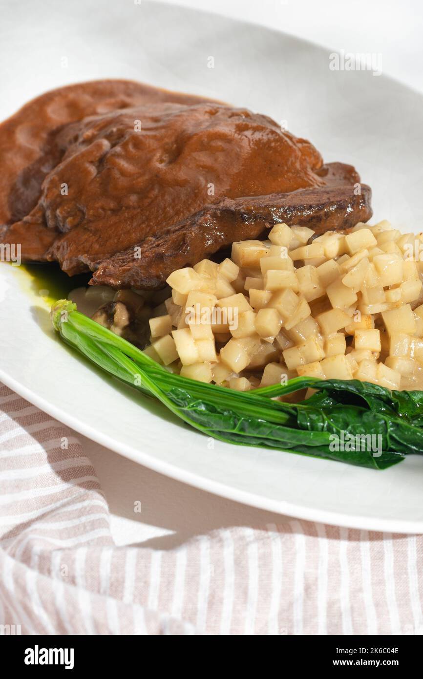 Traditional German braised beef cheeks in brown red wine sauce with