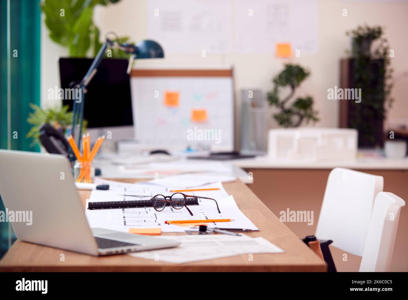 Empty Architects Office With Plans For New Building On Desk Stock Photo