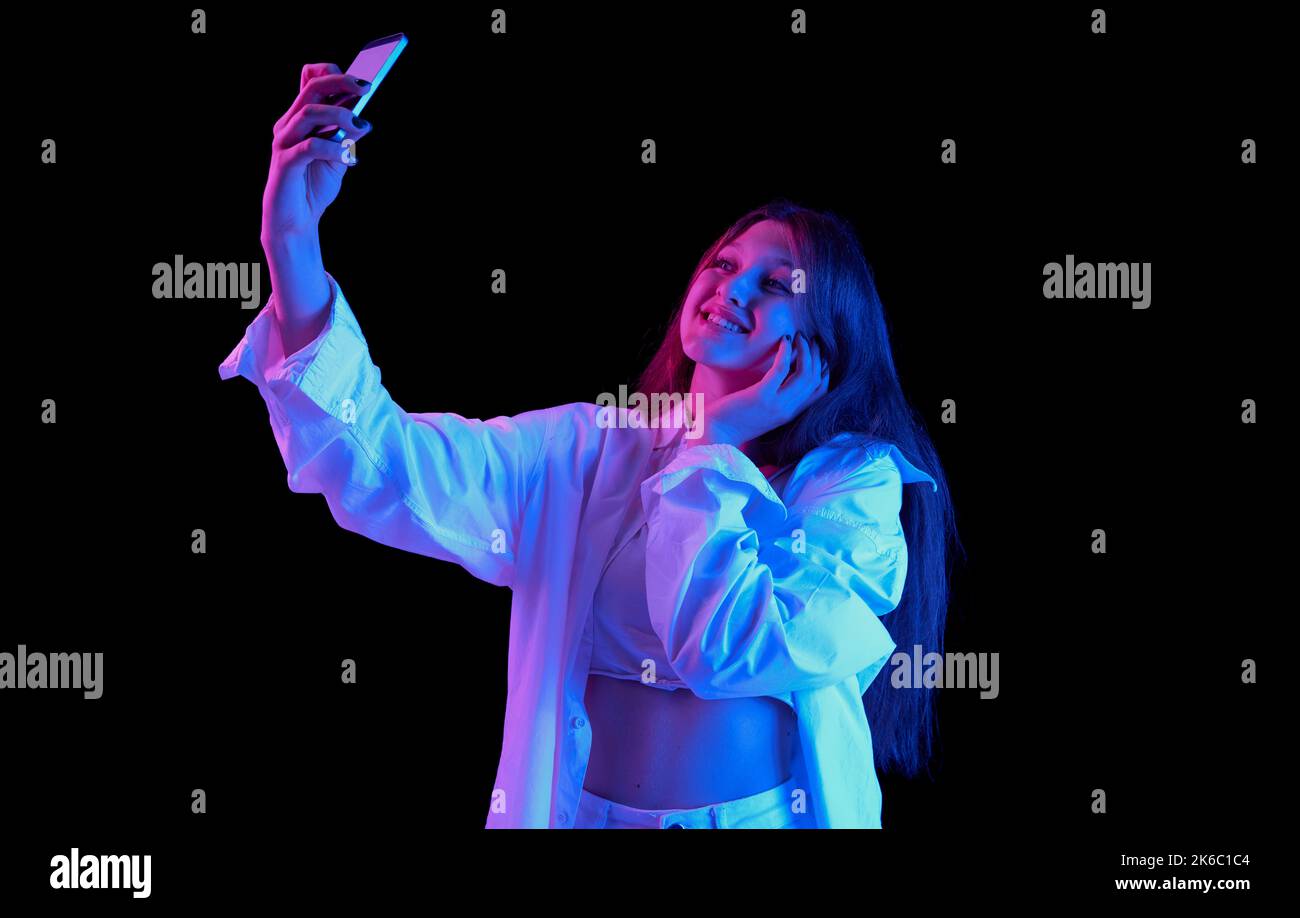 Portrait of young beautiful girl in white casual clothes taking selfie ...