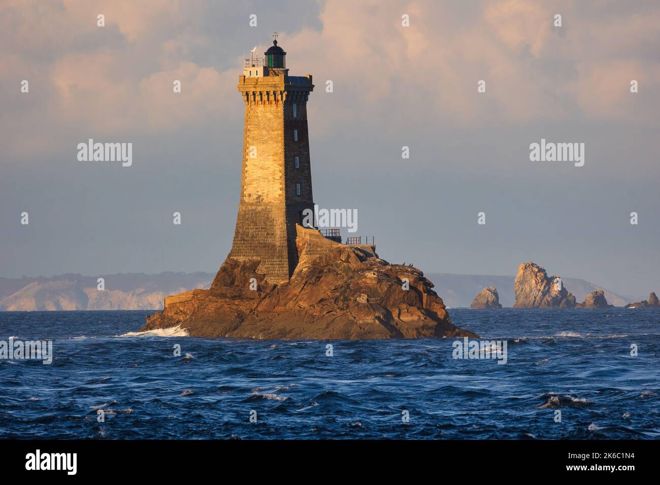 La vieille lighthouse isolated on a rock under un end afternoon sunlight Stock Photo