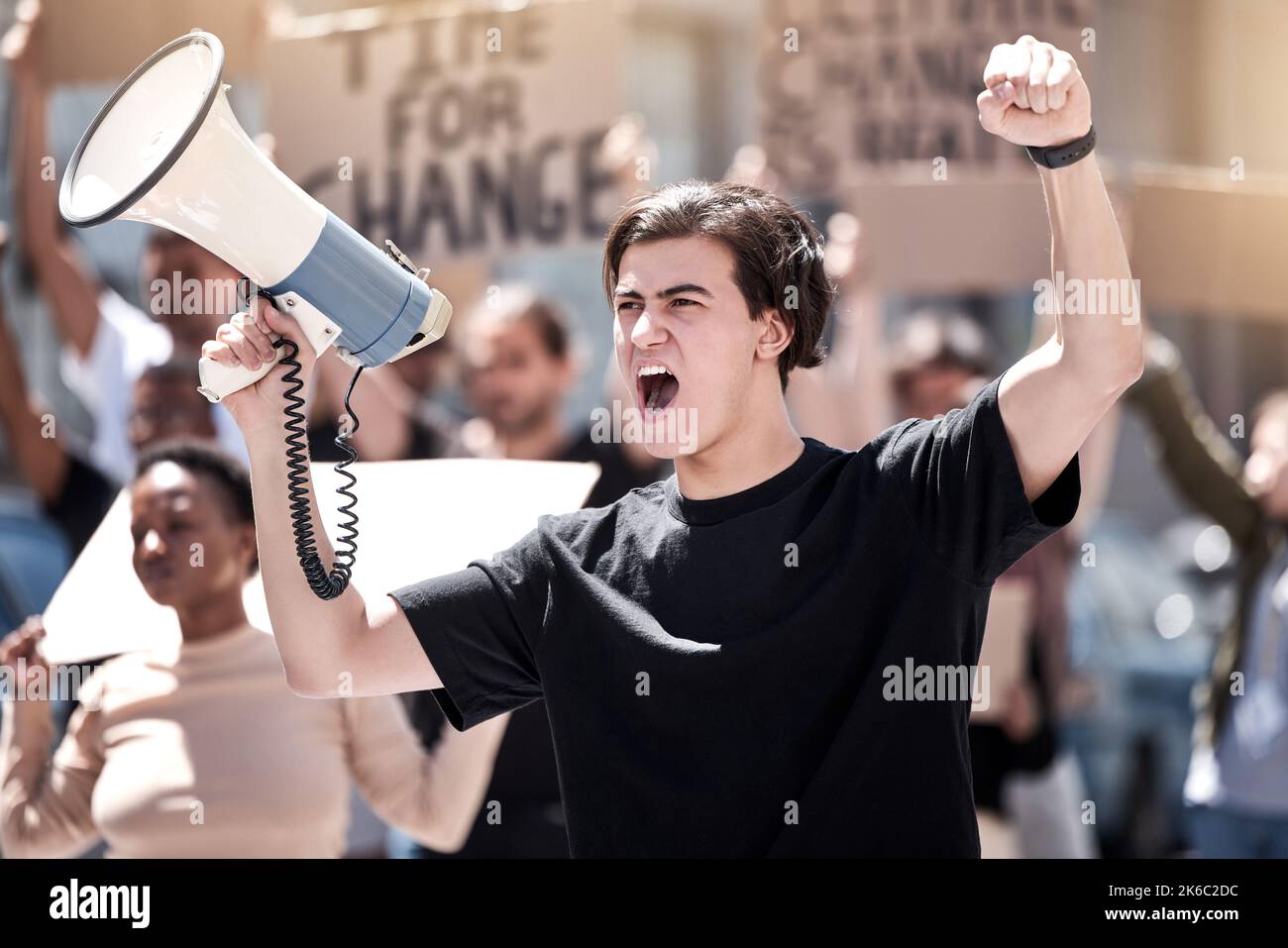 If we dont who will. a young man yelling through a megaphone during a protest. Stock Photo