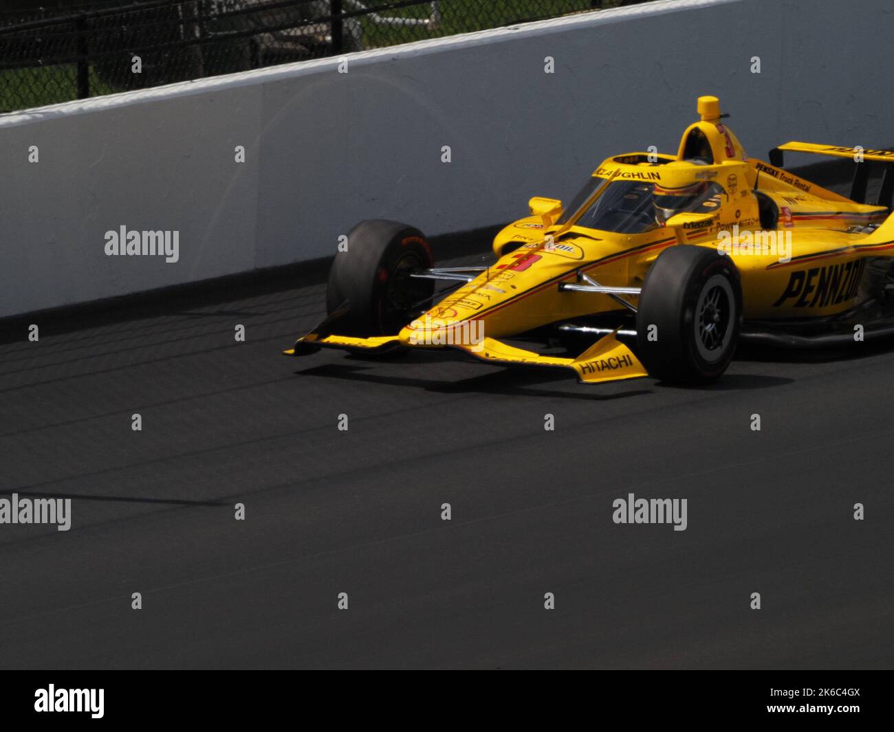 A shot of a yellow F1 race car, Indy 500 practice at the Indianapolis