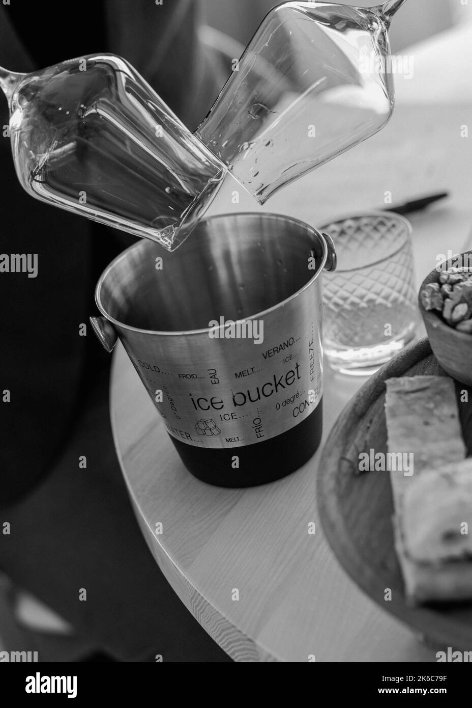 pouring wineglasses in spittoon at wine tasting black and white Stock Photo