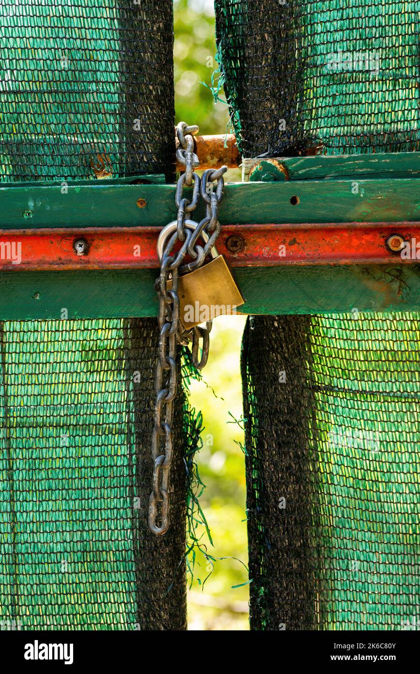 A gate closed with a lock and a chain Stock Photo