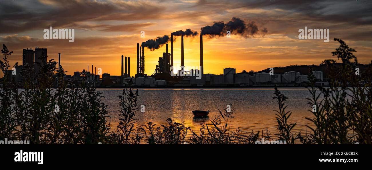 A beautiful silhouette of an industrial factory across the water at ...