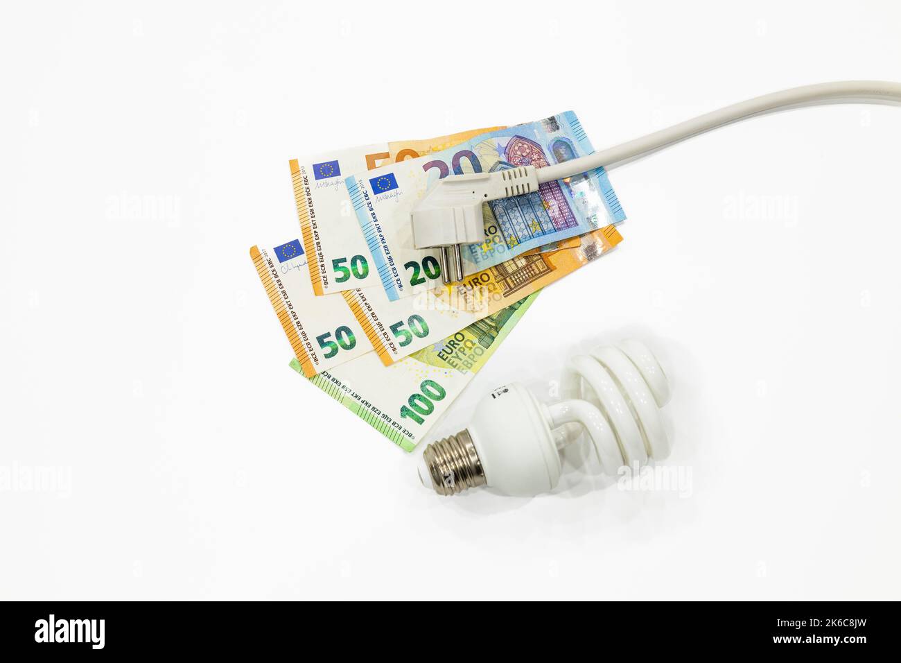 Electric plug, light bulb, and the euro money banknotes. Concept of expensive electricity costs Stock Photo
