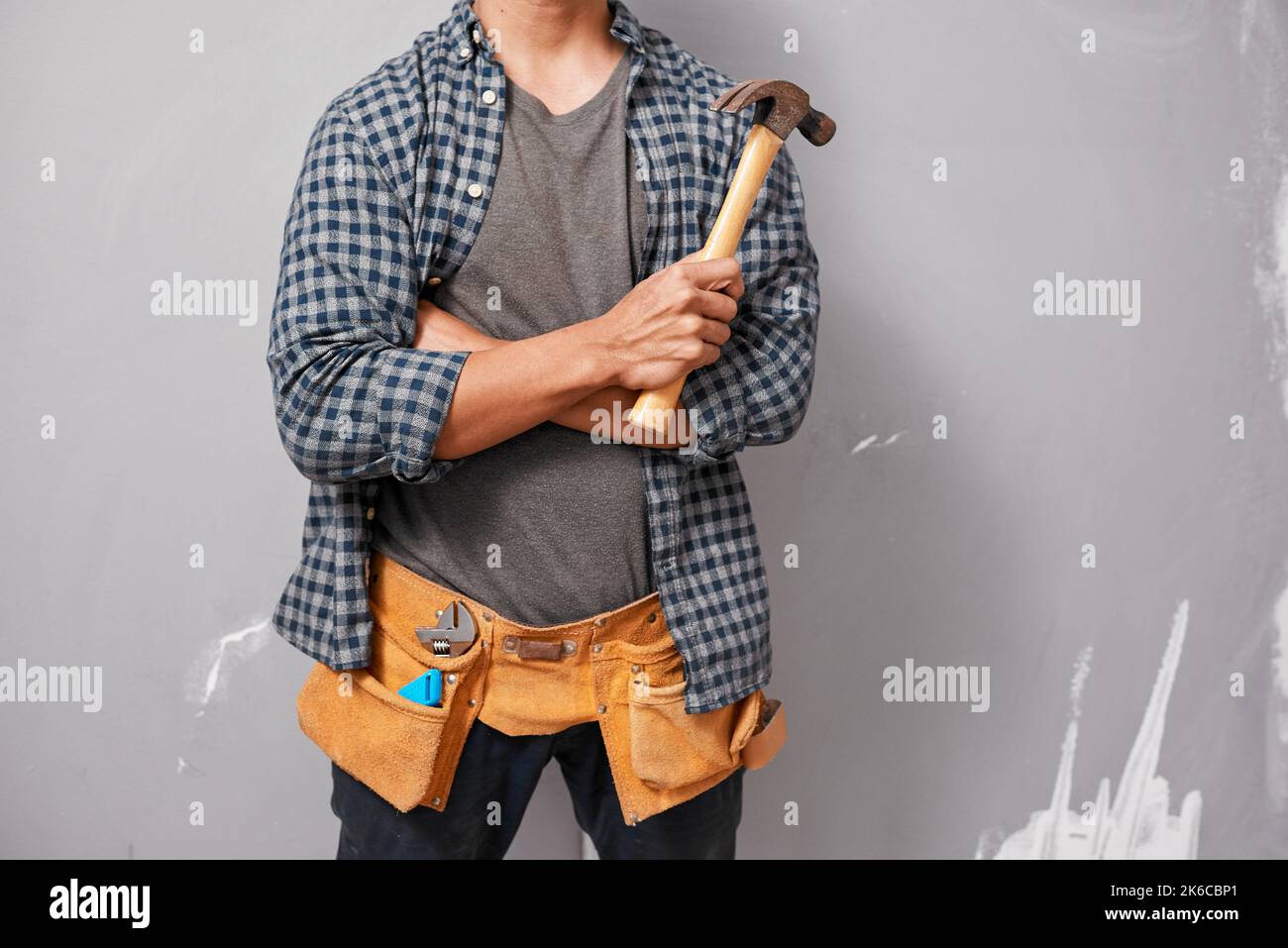 Cropped shot of a man holding hammer and wearing tool belt ready for DIY Stock Photo