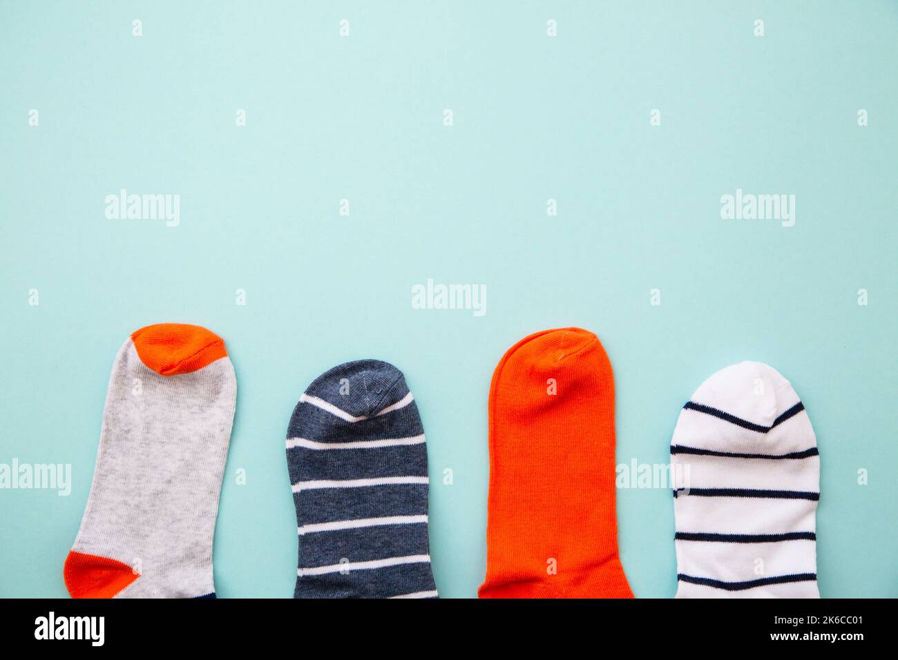 Odd socks day. Mismatch socks at blue background. Top view layout with