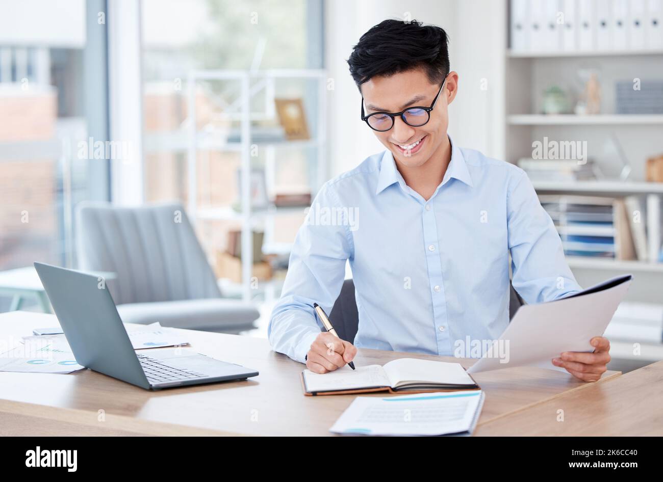 Writing it down helps me remember. a young businessman writing in a notebook at work. Stock Photo