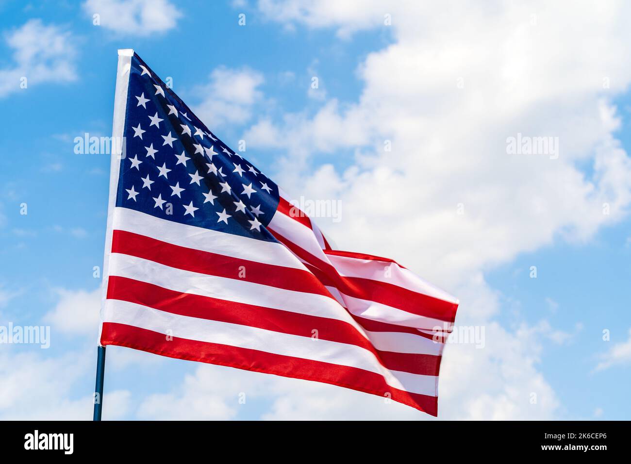American flag waving in the wind against blue sky Stock Photo - Alamy