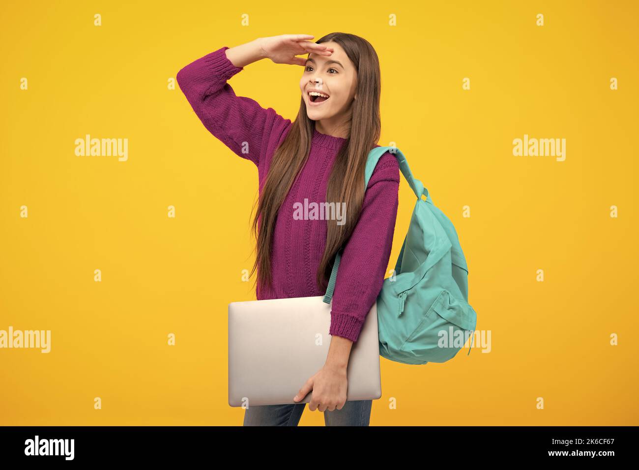 Excited face. Teen schoolgirl hold laptop on isolated studio background. Cchool student learning online, webinar, video lesson, distance education Stock Photo